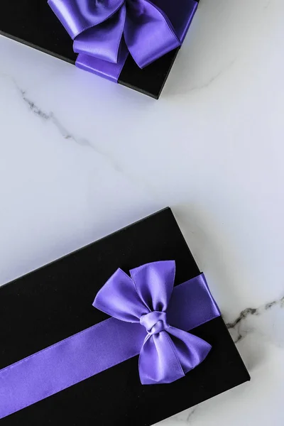 Розкішні святкові подарунки з лавандовою шовковою стрічкою та бантом на мармурі — стокове фото