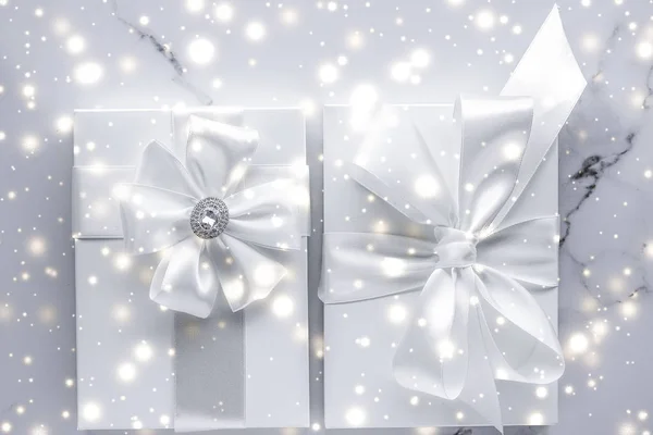 Luxury holiday gifts with white silk bow and ribbons on marble b