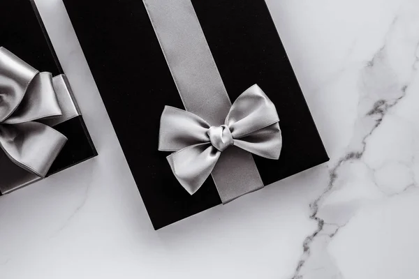 Luxus üdülési ajándékok ezüst selyem szalaggal és íj márvány b — Stock Fotó
