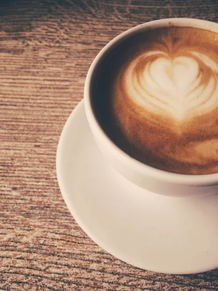 Bir kafeteryasıcak kapuçino Fincan, ahşap bir masada kahve i