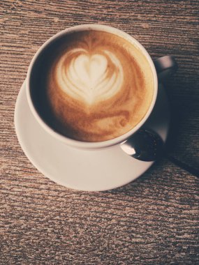 Bir kafeteryasıcak kapuçino Fincan, ahşap bir masada kahve i