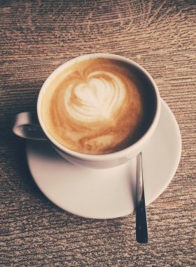 Bir kafeteryasıcak kapuçino Fincan, ahşap bir masada kahve i