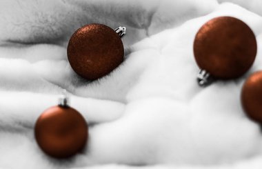 Beyaz kabarık kürk zemin üzerinde Çikolata kahverengi Noel baubles, 