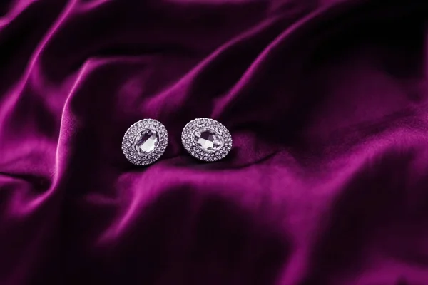 Pendientes de diamantes de lujo en tela de seda rosa oscuro, glamou de vacaciones —  Fotos de Stock