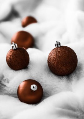 Beyaz kabarık kürk zemin üzerinde Çikolata kahverengi Noel baubles, 