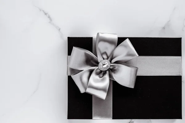 Luxury holiday gifts with silver silk ribbon and bow on marble b — Stock Photo, Image