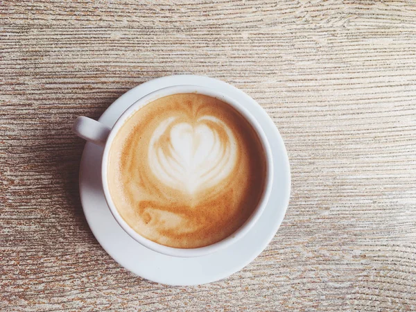 Secangkir cappuccino panas di kantin, kopi di atas meja kayu i — Stok Foto