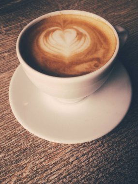 Bir kafeteryasıcak kapuçino Fincan, ahşap bir masada kahve i