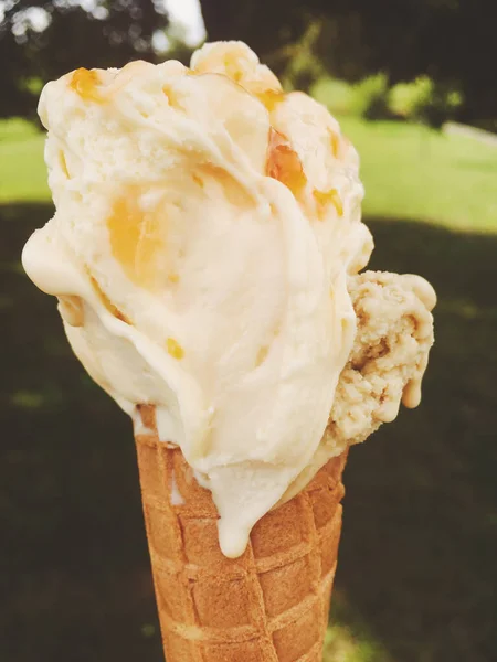 Ice cream cone melting outdoors in summer, sweet dessert food on — Stock Photo, Image