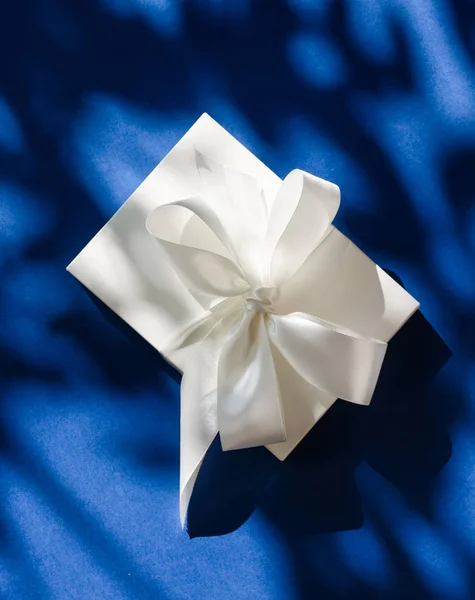 Luxo feriado caixa de presente branco com fita de seda e arco em azul b — Fotografia de Stock