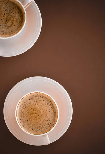 Xícara de café quente como bebida de café da manhã, copos flatlay em parte traseira marrom — Fotografia de Stock