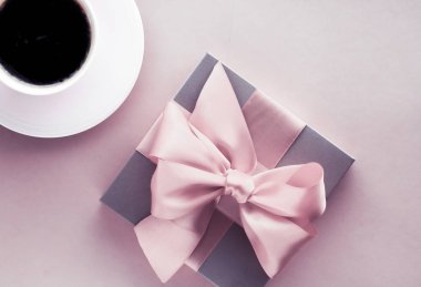 Allık pembe arka plan üzerinde Lüks hediye kutusu ve kahve fincanı, flatlay