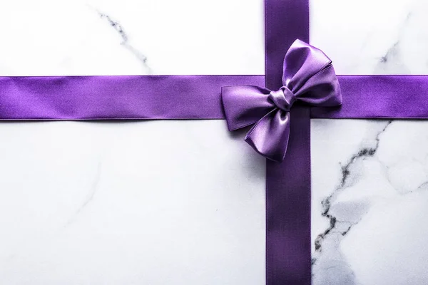 Фіолетова шовкова стрічка і лук на розкішному мармуровому фоні, свято — стокове фото