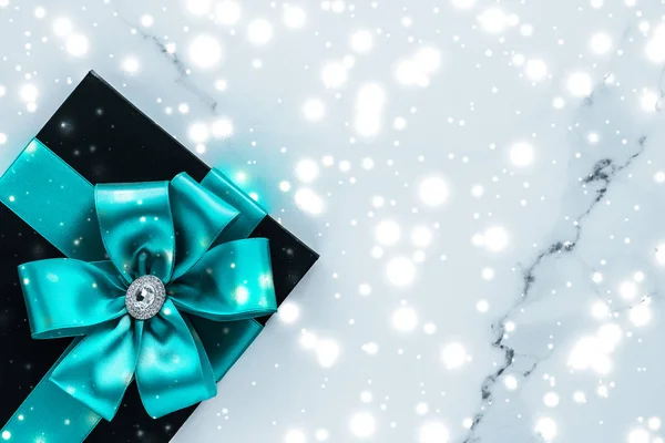Regalos de vacaciones de invierno con arco de seda esmeralda y nieve brillante en f — Foto de Stock