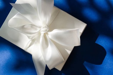 Mavi b üzerinde ipek kurdele ve yay ile lüks tatil beyaz hediye kutusu