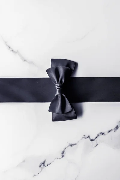 Nastro di seta nera e fiocco su sfondo marmo, flatlay — Foto Stock