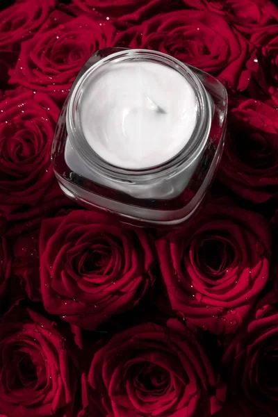 Rosto creme hidratante da pele e rosas vermelhas flores, skinca luxo — Fotografia de Stock