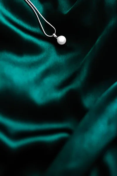 Luxuoso colar de pérolas de ouro branco na seda verde-esmeralda escura de volta — Fotografia de Stock