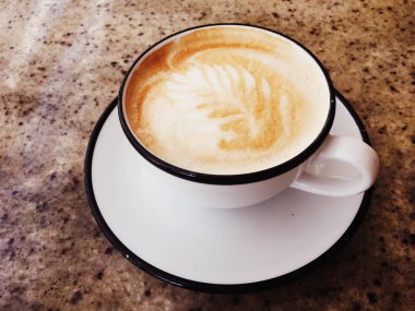 Kafeteryada kahvaltı için Cappuccino, pa masada kahve fincanı