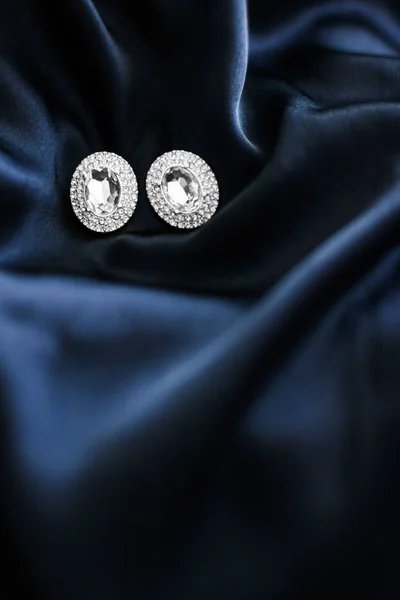 Pendientes de diamantes de lujo sobre fondo de seda azul oscuro, gl vacaciones —  Fotos de Stock