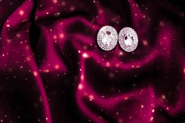 Роскошные бриллиантовые серьги на темно-красном шелке со снежным блеском, холи — стоковое фото