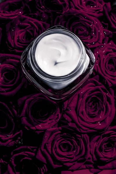 Rosto creme hidratante da pele e flores roxas escuras, pele de luxo — Fotografia de Stock