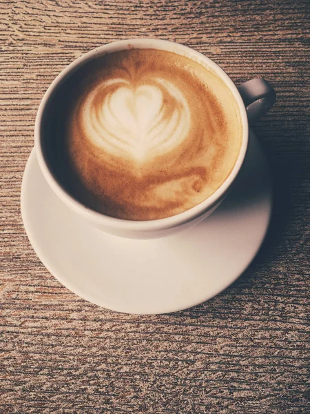 Xícara de cappuccino quente em uma cafetaria, café em uma mesa de madeira i — Fotografia de Stock