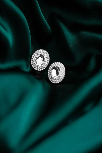 Lyxiga diamantörhängen på mörkt smaragdgrönt siden, Holiday Glam — Stockfoto