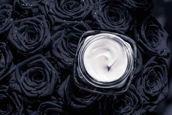 Yüz kremi cilt nemlendirici ve siyah gül çiçekler, lüks cilt — Stok fotoğraf