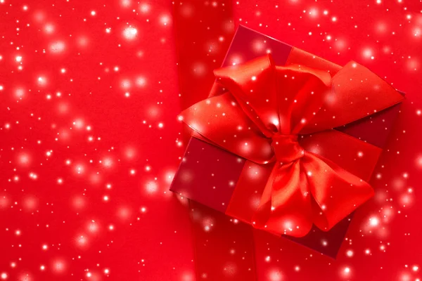 Presentes de férias de inverno e neve brilhante no fundo vermelho, Christm — Fotografia de Stock