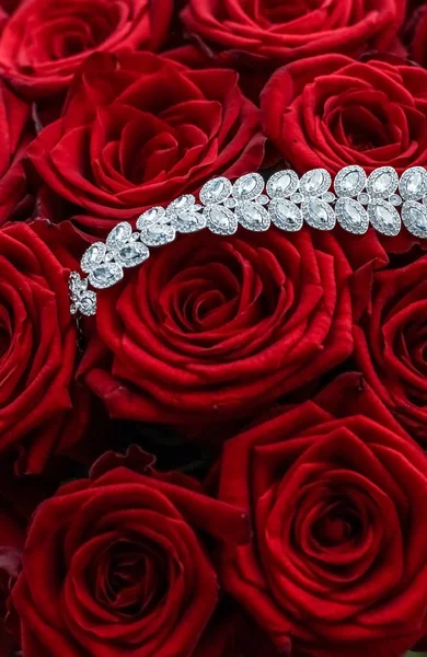 Luksusowa bransoletka diamentowa i bukiet czerwonych róż, biżuteria miłość g — Zdjęcie stockowe