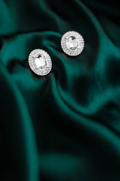 Pendientes de diamantes de lujo en seda verde esmeralda oscura, glamour navideño —  Fotos de Stock