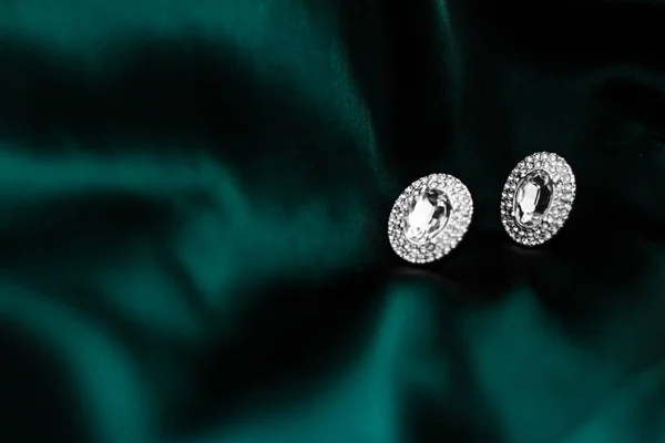 Pendientes de diamantes de lujo en seda verde esmeralda oscura, glamour navideño —  Fotos de Stock