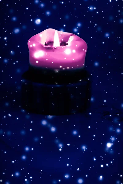 Pink holiday candle on blue sparkling snowing background, luxury — Stock Photo, Image