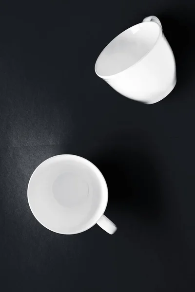 Ensemble de vaisselle en vaisselle blanche, tasse vide sur fond plat noir — Photo