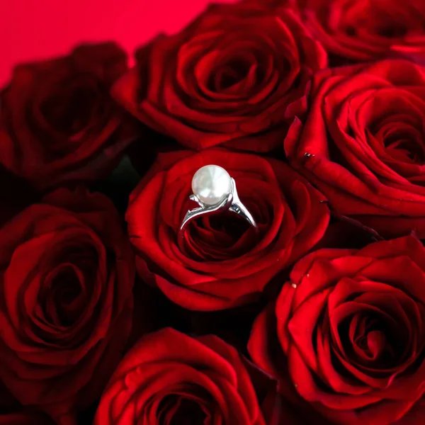 Beautiful white gold pearl ring and bouquet of red roses, luxury — Stock Photo, Image