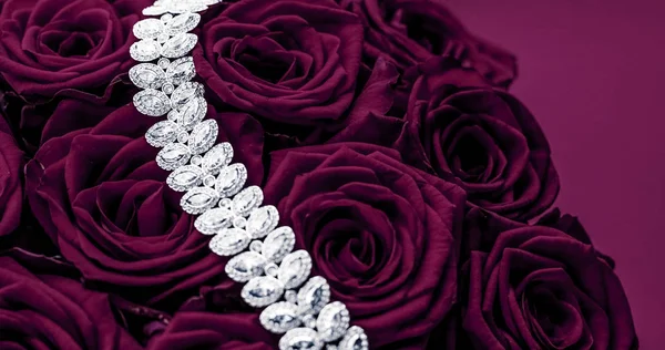 Luxury diamond jewelry bracelet and purple roses flowers, love g