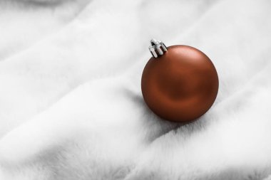 Beyaz kabarık kürk zemin üzerinde Çikolata kahverengi Noel baubles, 