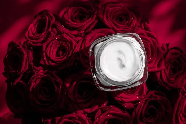Крем для лица увлажняющий кожу и красные розы цветы, роскошная кожа — стоковое фото