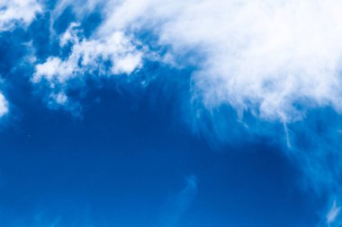 Mavi gökyüzü arkaplanı, beyaz bulutlar ve parlak güneş ışığı