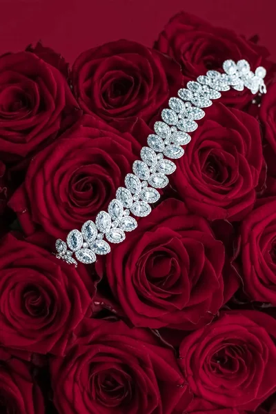 Luxury diamond jewelry bracelet and red roses flowers, love gift