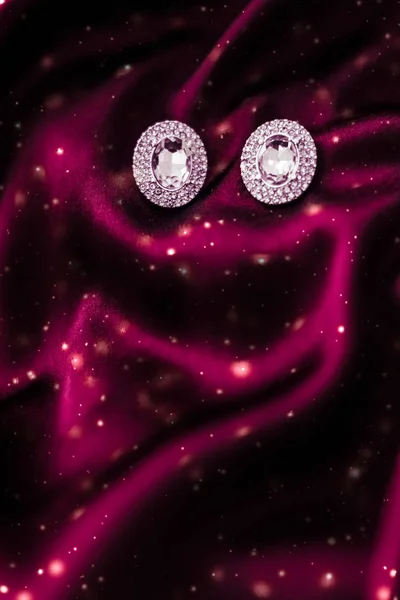 Luxus-Diamant-Ohrringe auf dunkelroter Seide mit Schneeglitzern, Holi — Stockfoto