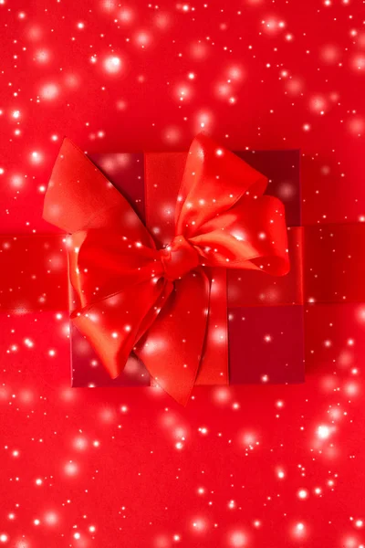 Kırmızı arka planda kış tatil hediyeleri ve parlayan kar, christm — Stok fotoğraf