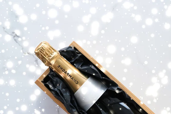 Різдвяна пляшка шампанського та подарункова коробка та блискучий сніг — стокове фото