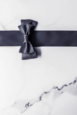 Siyah ipek kurdele ve yay mermer arka planda, yatık