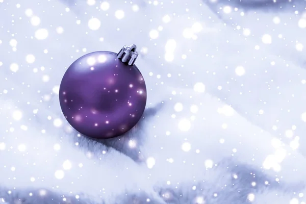 Boules de Noël violettes sur fourrure duveteuse avec paillettes de neige, luxe — Photo
