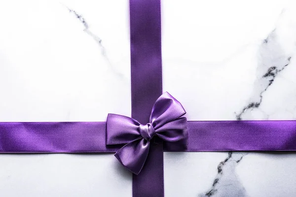 紫色のシルクのリボンと豪華な大理石の背景に弓、休日 — ストック写真