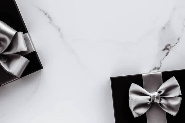 Presentes de férias de luxo com fita de seda prata e arco em mármore b — Fotografia de Stock