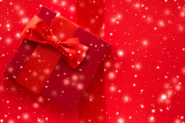 Зимний праздник подарки и светящийся снег на красном фоне, Рождество — стоковое фото