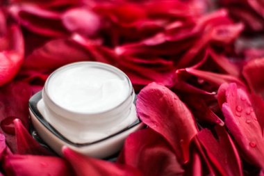 Kırmızı çiçek yaprakları ve WA Hassas Cilt Bakımı nemlendirici krem